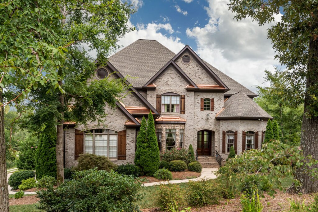 French country brick home with a copper roof accent