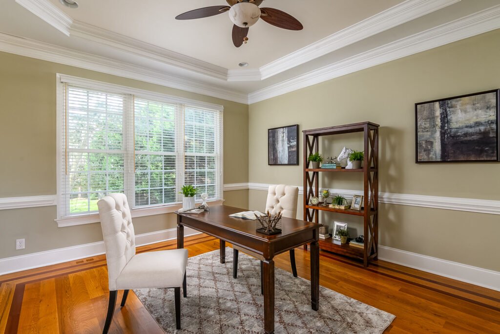 Home office with a tray ceiling and hardwood floors