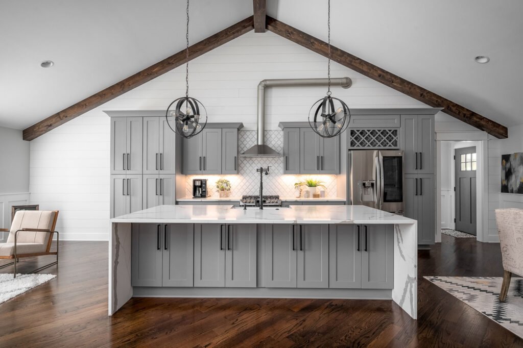 Kitchen with vaulted ceiling beams and a waterfall island
