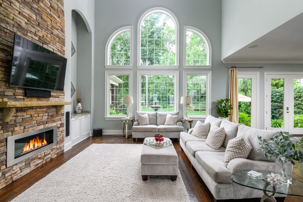 Living room with arched windows and a stone fireplace