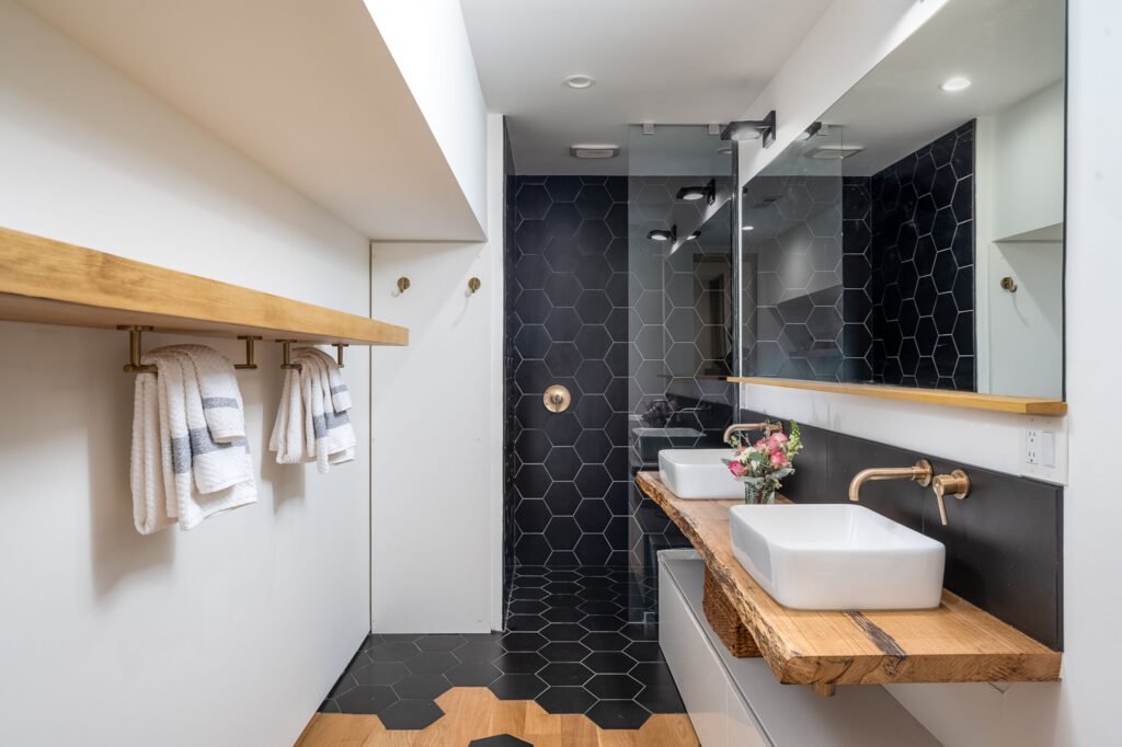 Bathroom with black hex tile flooring and a vessel sink