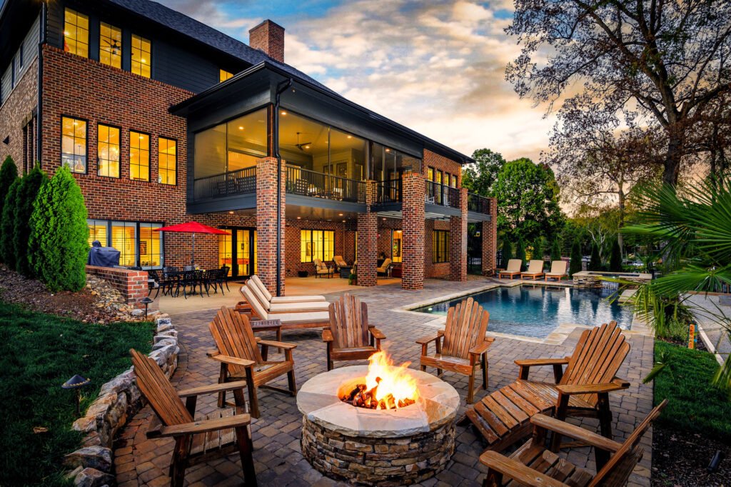 Backyard fire pit and lit pool photographed at twilight